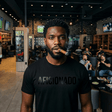 Black T-Shirt with Black Aficionado Logo on Black Male Smoking a cigar in Aficionados Lounge