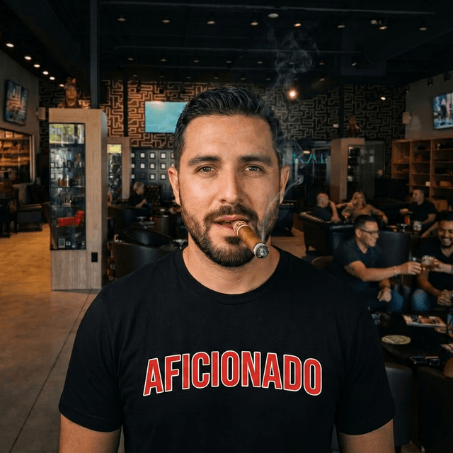 Black T-Shirt with Red Aficionado Logo on White Male Smoking a Cigar in Aficionados Lounge